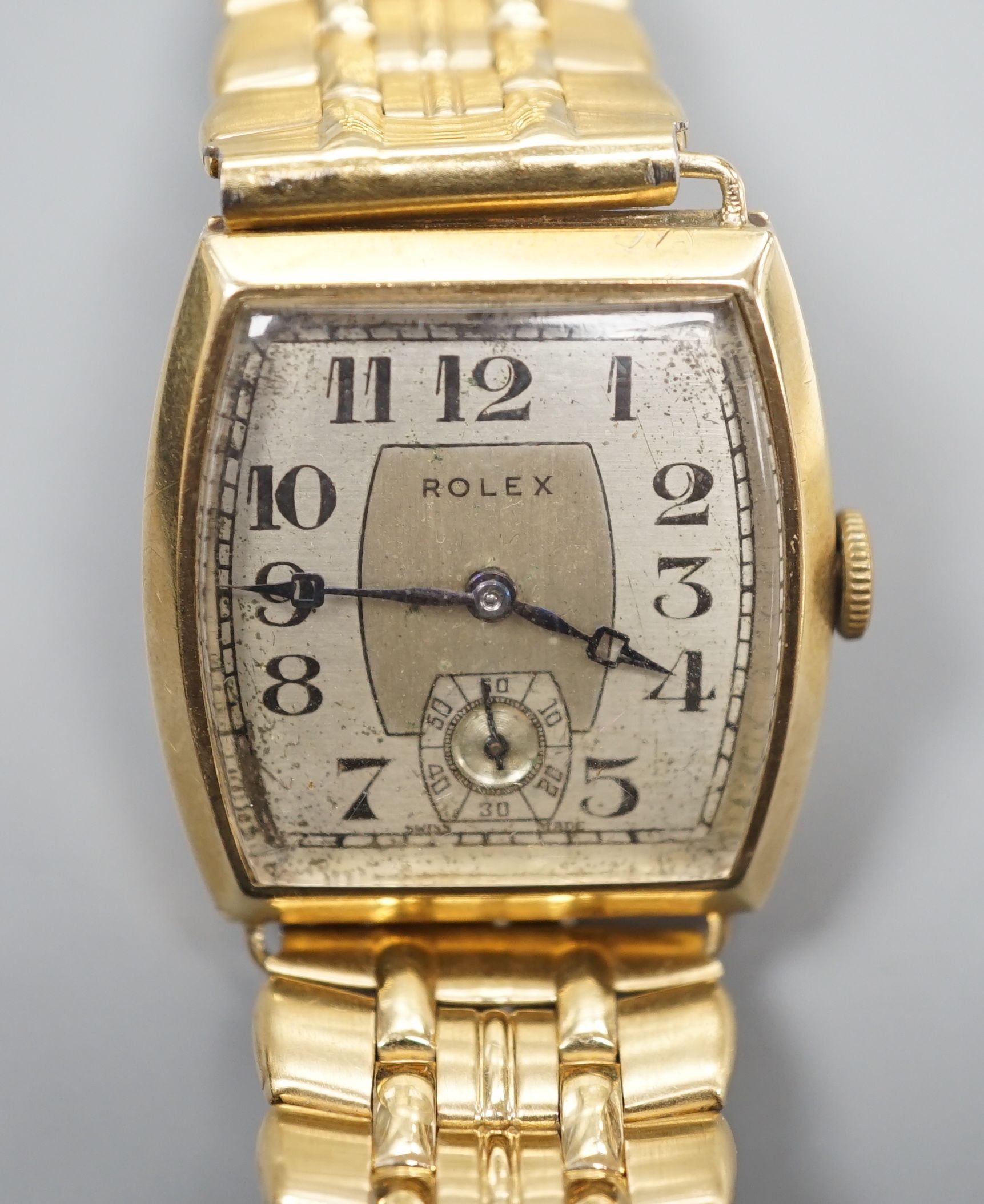 A gentleman's early 1930's 9ct gold Rolex manual wind wrist watch, with tonneau shaped case and Arabic dial with subsidiary seconds, on associated bracelet, case diameter 28mm.
